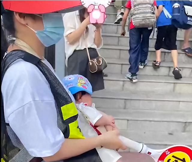 女子抱婴儿校门口站岗40分钟，称被家委会逼迫排班？教育局回应→